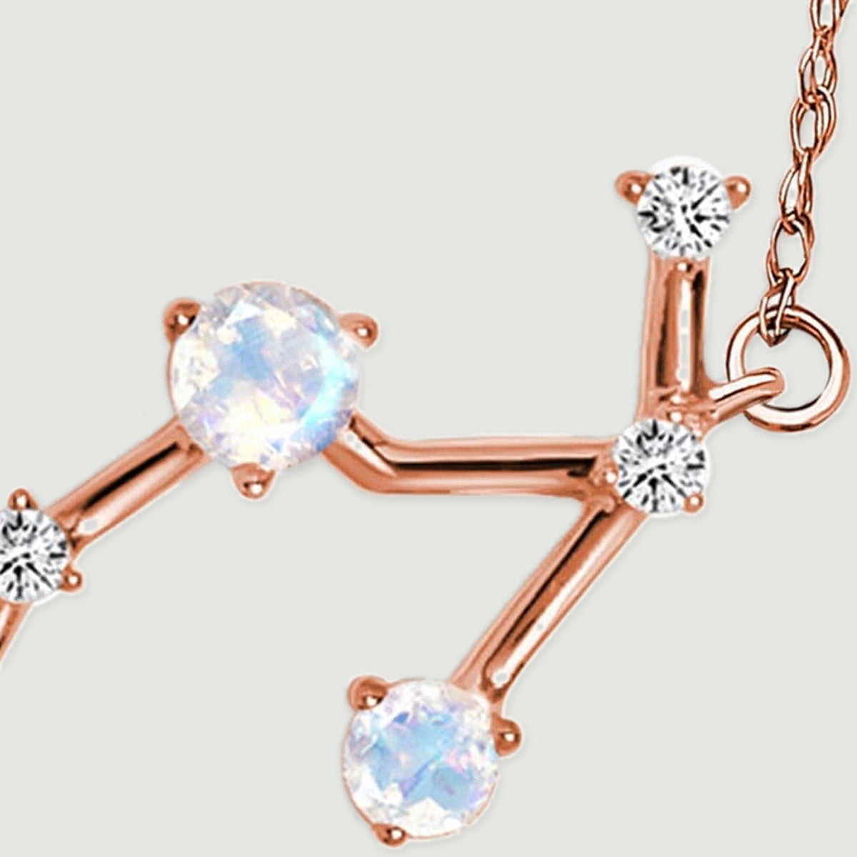 Two moonstones and three diamond accents meet along the branching rose gold section of the pendant.