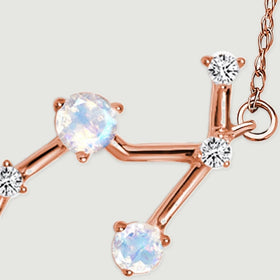 Two moonstones and three diamond accents meet along the branching rose gold section of the pendant.
