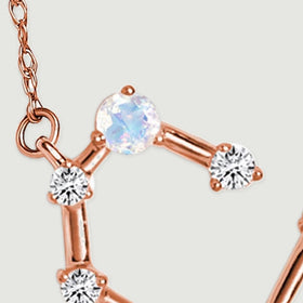 The left chain attachment leads to a moonstone and three diamond accents on rose gold links.
