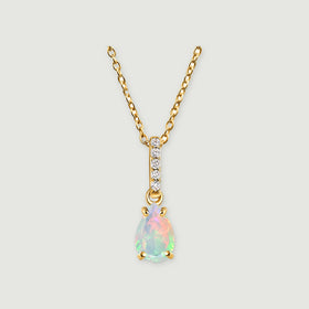 A yellow gold necklace has a pear-shaped opal below a vertical row of five clear stones on a light gray background.