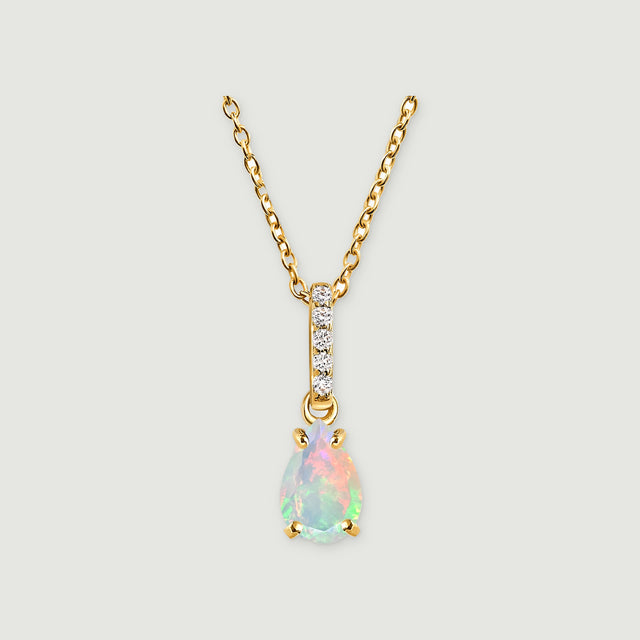 A yellow gold necklace has a pear-shaped opal below a vertical row of five clear stones on a light gray background.