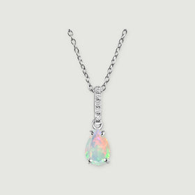 A silver chain meets a slim stone-set bail above a colorful teardrop opal on light gray.
