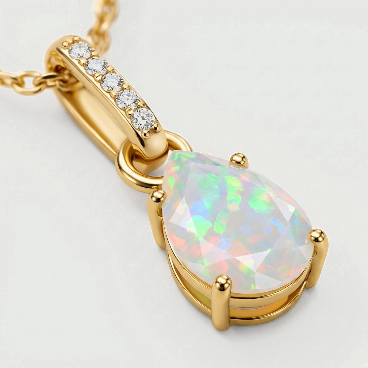 An angled view shows the yellow gold prongs, open-sided opal setting and five clear stones along the bail.