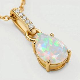 An angled view shows the yellow gold prongs, open-sided opal setting and five clear stones along the bail.