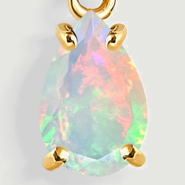 The front of a pear-shaped opal shows pink and green flashes between four rounded yellow gold prongs.