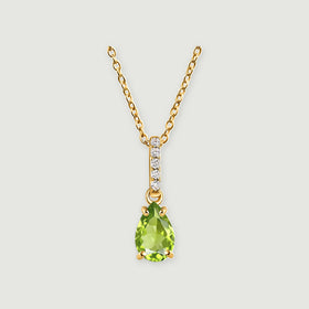 A pear-shaped green peridot hangs below a white-stone bail on a yellow gold vermeil chain against a light gray background.