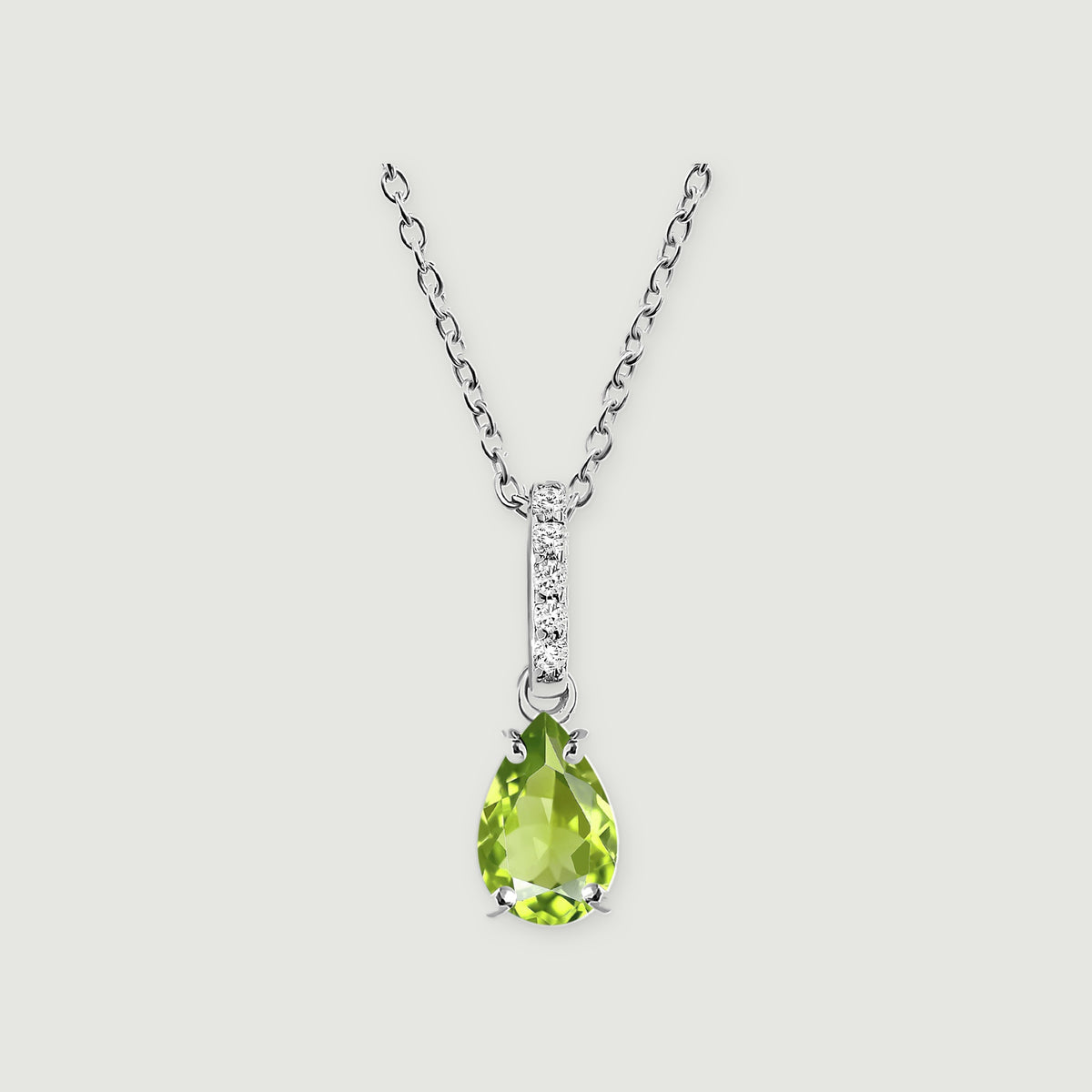 The sterling silver necklace has a faceted green pear pendant and a slim bail set with five white stones on light gray.