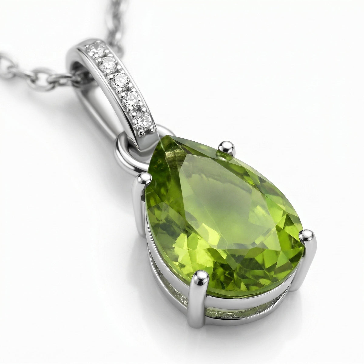 The green peridot facets and open sterling silver setting are visible beside the stone-set bail on a clean white surface.