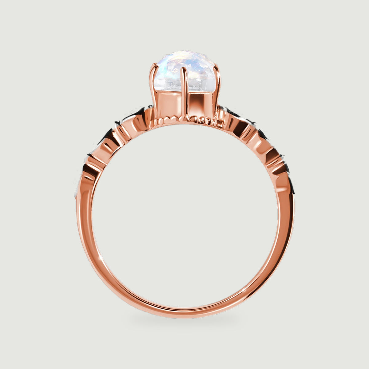 The side of a rose gold ring shows the raised moonstone setting and curved polished band.