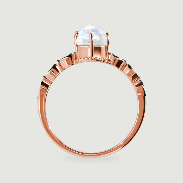 The side of a rose gold ring shows the raised moonstone setting and curved polished band.