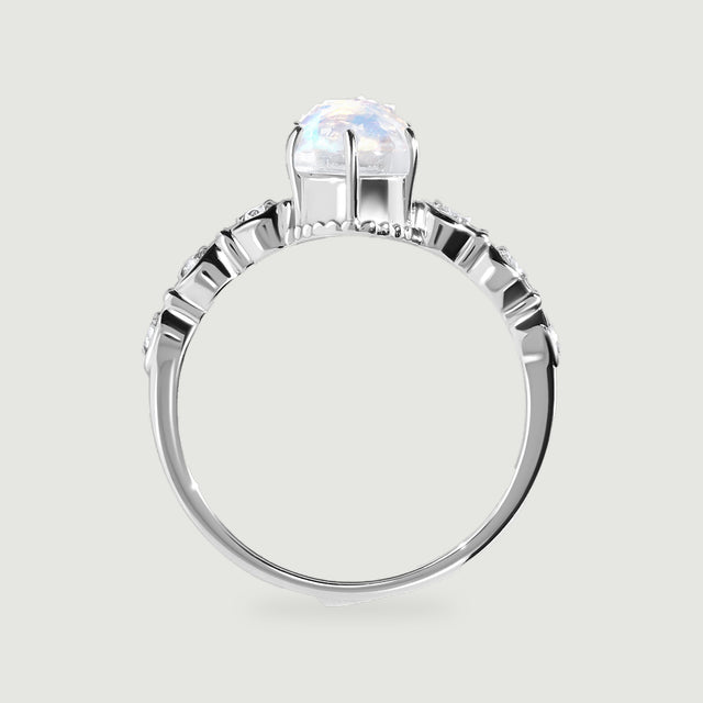 A white gold ring is shown from the side with an open setting beneath the faceted oval stone.
