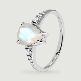 The white gold ring is shown upright at an angle with its open band and moonstone prongs visible.