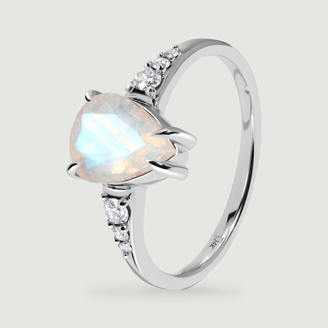 The white gold ring is shown upright at an angle with its open band and moonstone prongs visible.