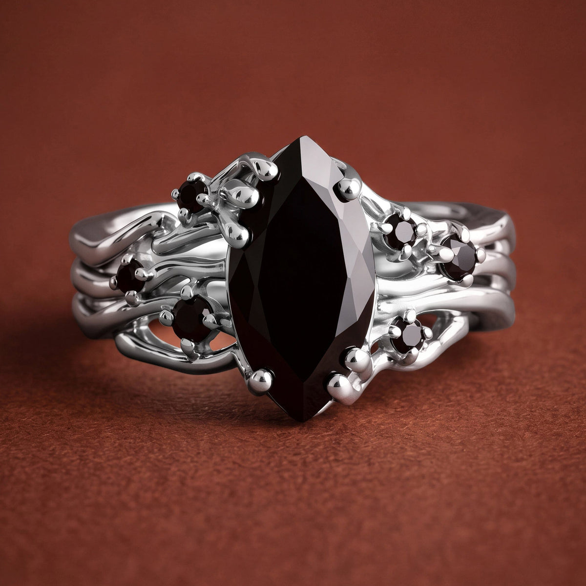 The silver ring is viewed from the front on a clean warm stone surface.