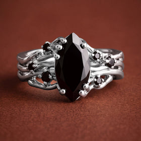 The silver ring is viewed from the front on a clean warm stone surface.
