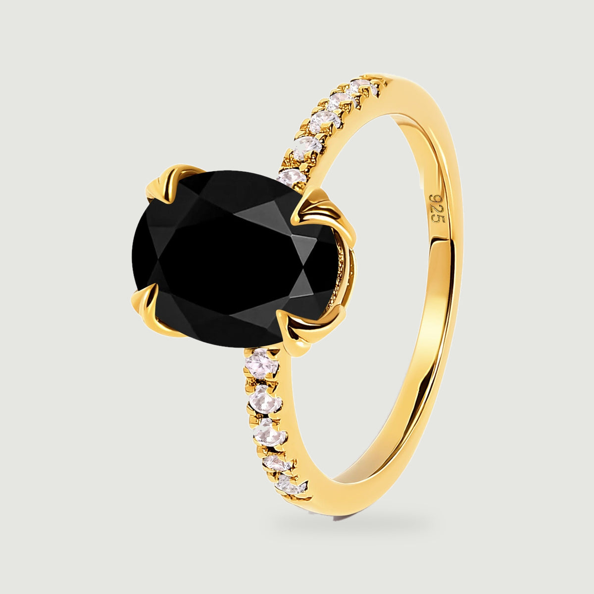 An angled view shows the yellow gold ring band, raised oval black stone and clear stones along the shoulders.