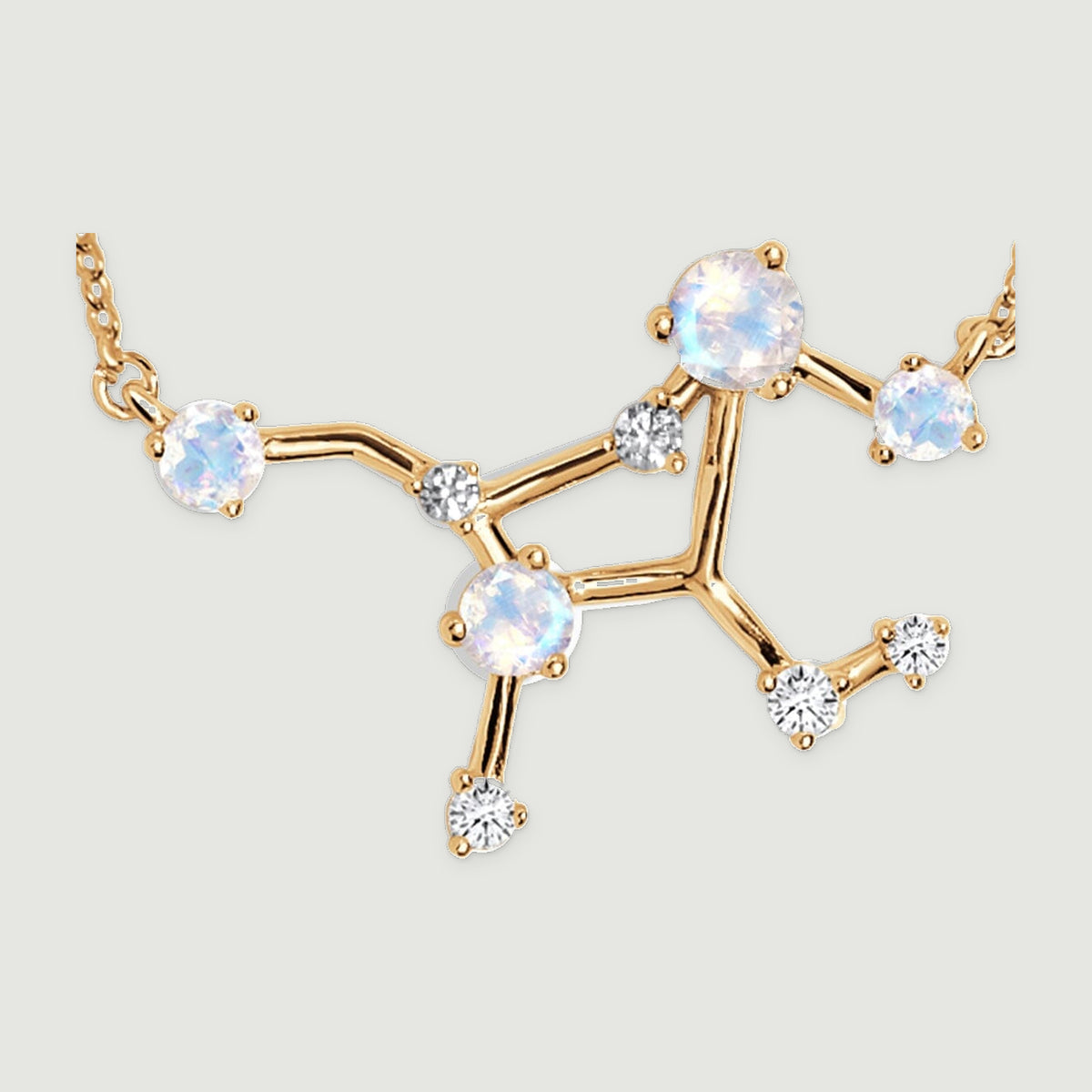Round pale stones and small clear stones sit in yellow gold prongs along an open branching necklace centre.