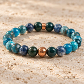New close view of the copper round bead, bloodstone and blue apatite on travertine
