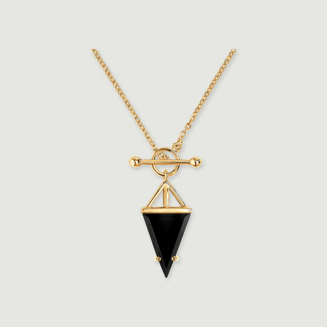 A yellow gold necklace with a black triangular pendant is centered on a light gray background.