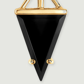 A close-up reveals the black stone facets and two small gold prongs near the pointed tip.