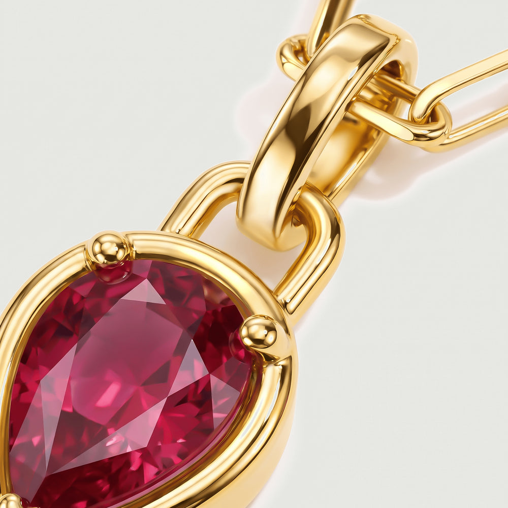 A close view shows red gemstone facets, rounded gold prongs, and a broad polished pendant bail.