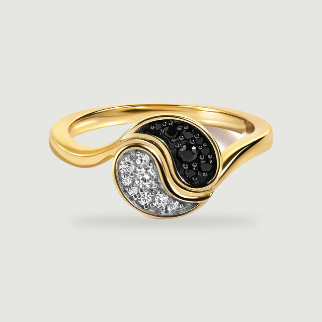A yellow gold plated ring with curved black and clear stone sections is centered on a light grey background.