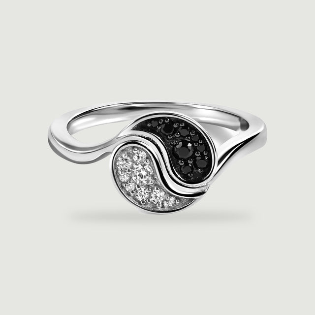 A rhodium plated ring shows a polished curved band and contrasting black and clear stones on light grey.