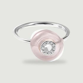 A sterling silver band supports a polished rose quartz disc with clear stones around its central opening.