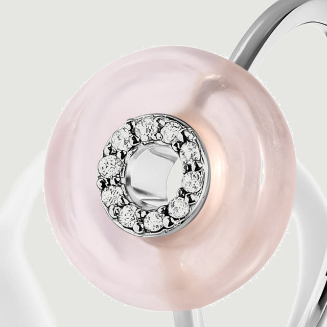 The rose quartz disc is shown at an angle with clear stones held in a sterling silver circular setting.