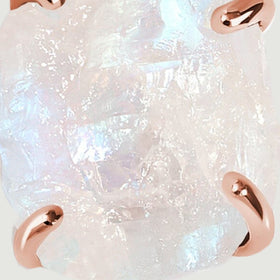 Blue and pearly flashes appear across the uneven surface of the moonstone between rose gold prongs.