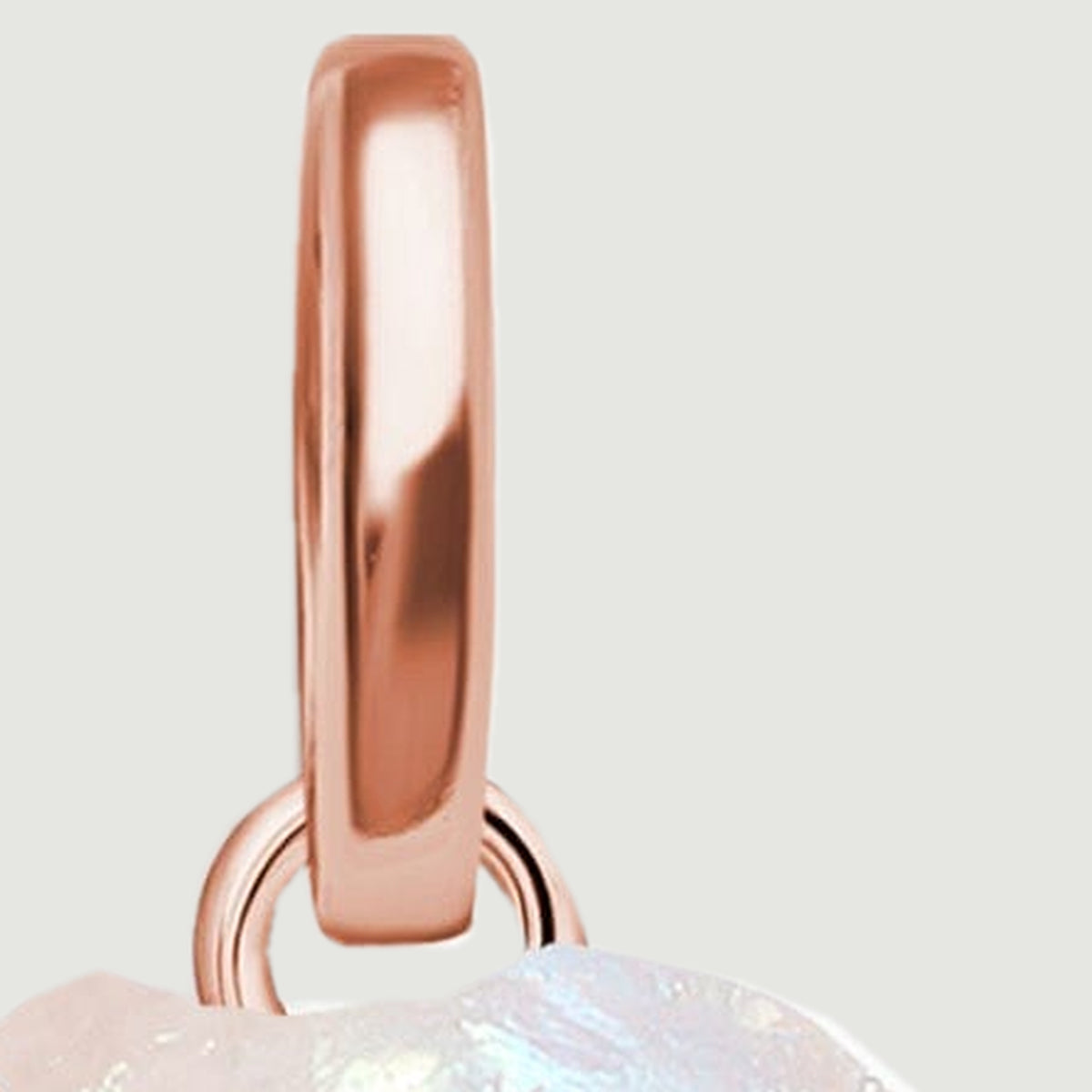 The polished rose gold bail connects to a round loop above the rough moonstone.