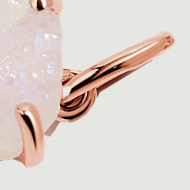 A close side view shows the rose gold bail, connecting loop and lower prong beside the moonstone edge.