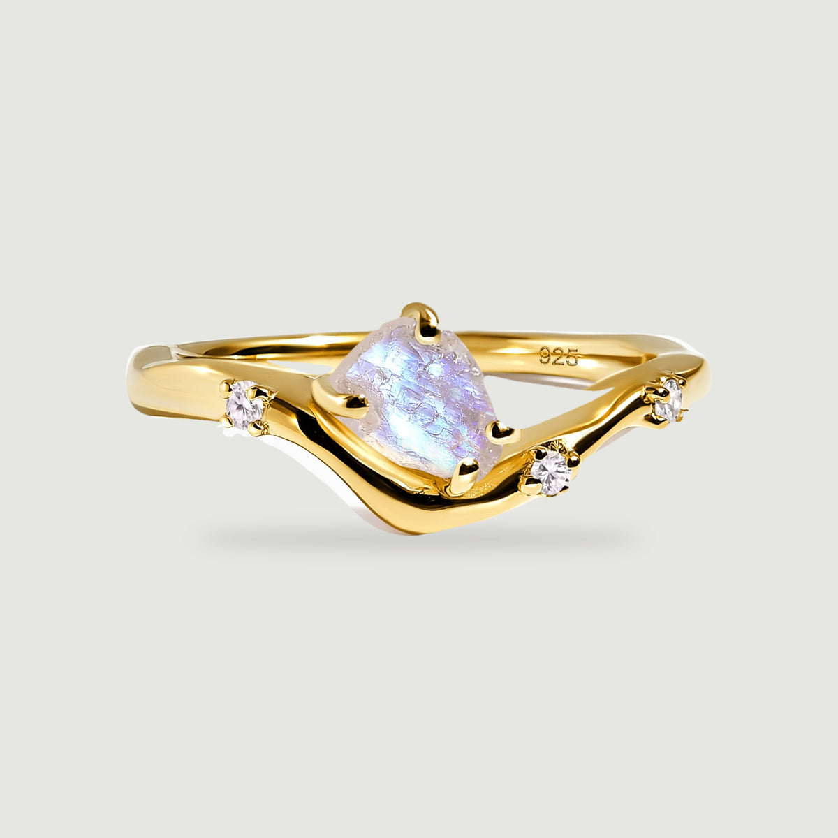 A yellow gold vermeil wishbone ring shows its pale iridescent moonstone above a softly shaded gray background.