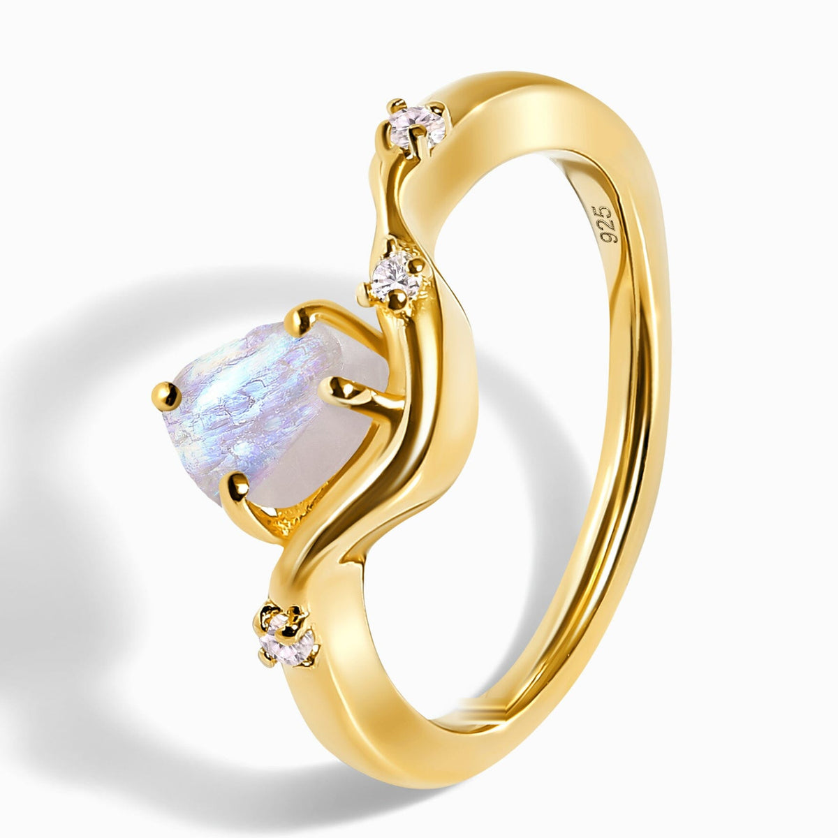 The yellow gold vermeil ring lies at an angle, with its rough moonstone, clear accent stones, and open band visible.