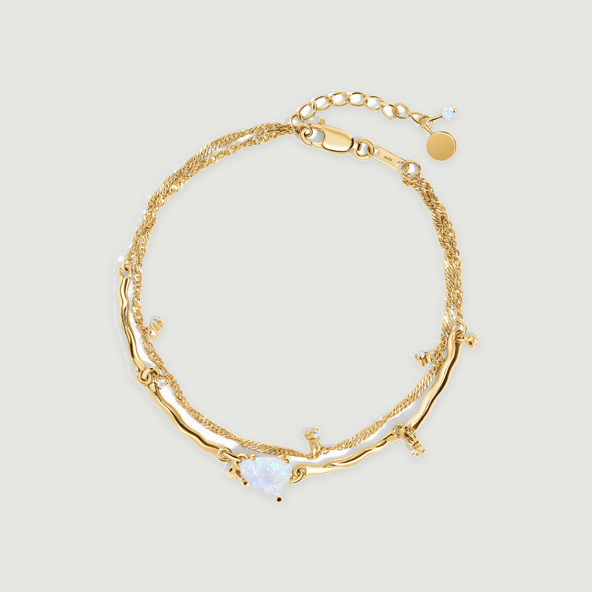 A yellow gold vermeil bracelet is centered on light gray with a pale moonstone, curved polished links and an extension chain.
