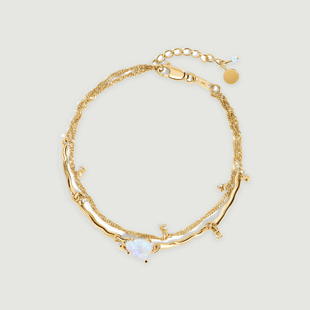 A yellow gold vermeil bracelet is centered on light gray with a pale moonstone, curved polished links and an extension chain.