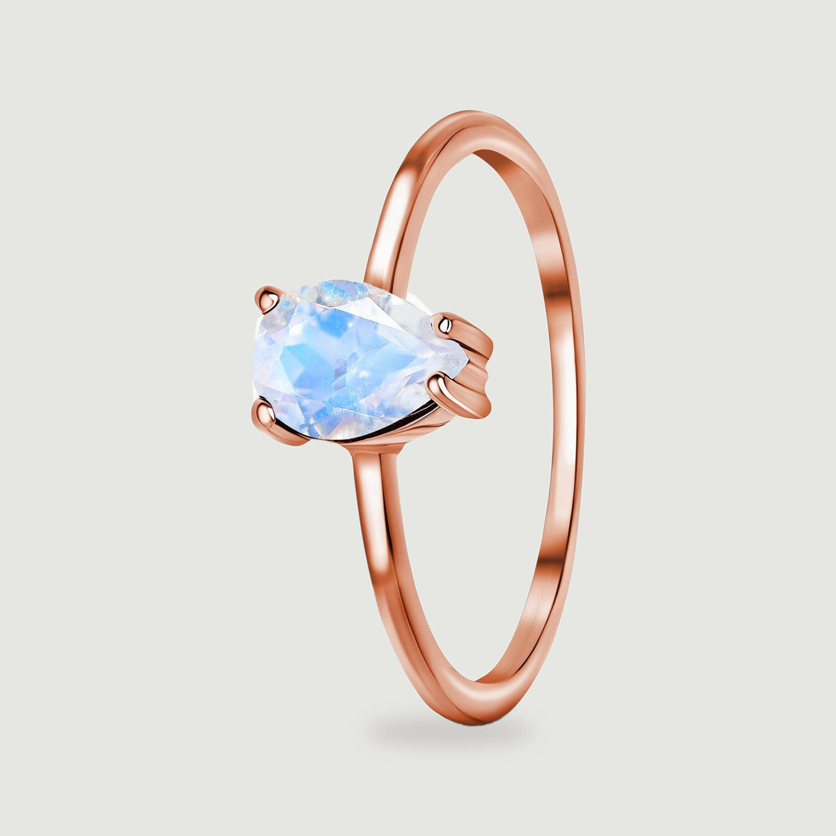 An angled view shows the pear-shaped moonstone setting and the slim rounded rose gold band.