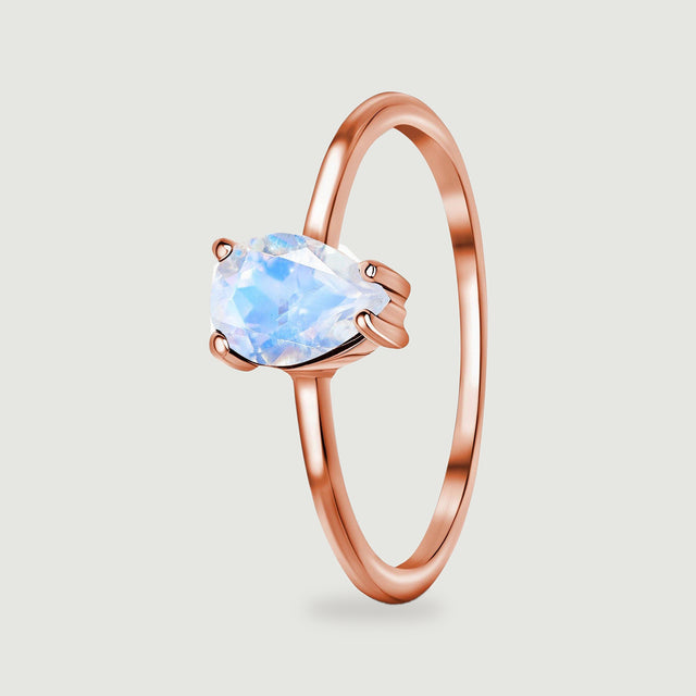 An angled view shows the pear-shaped moonstone setting and the slim rounded rose gold band.